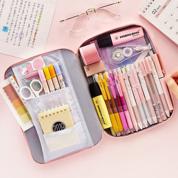 Pencil case with stationery items on a pink surface